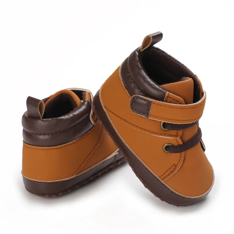 Pair of brown leather baby shoes on a white background