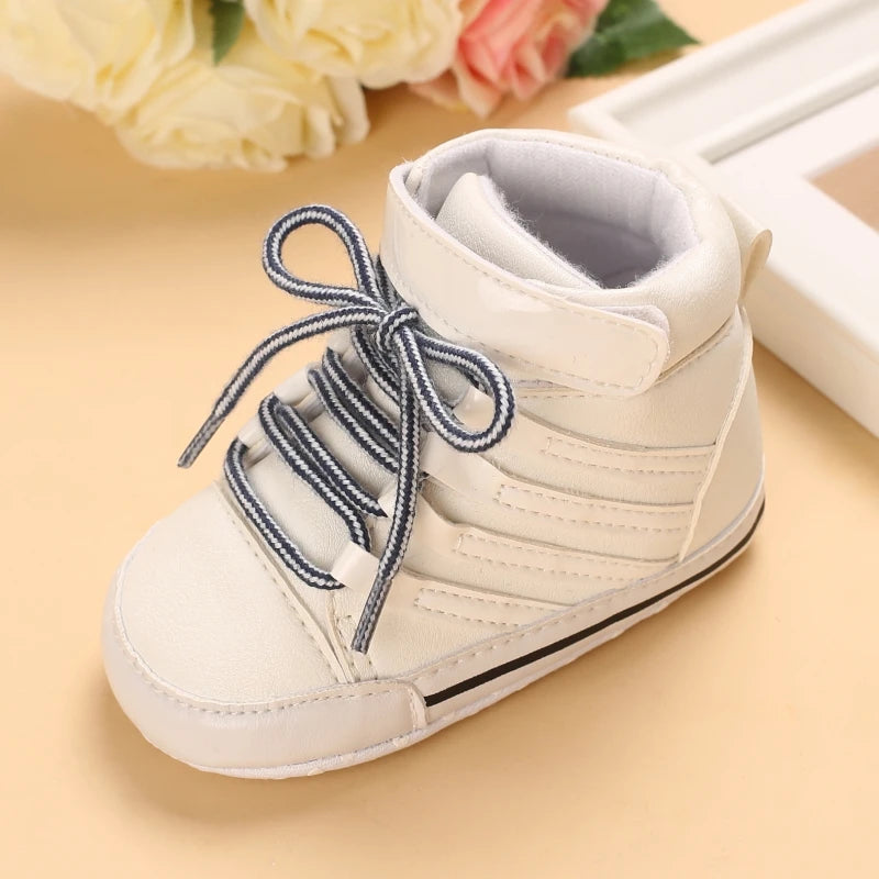 White baby shoe with blue laces on a beige background