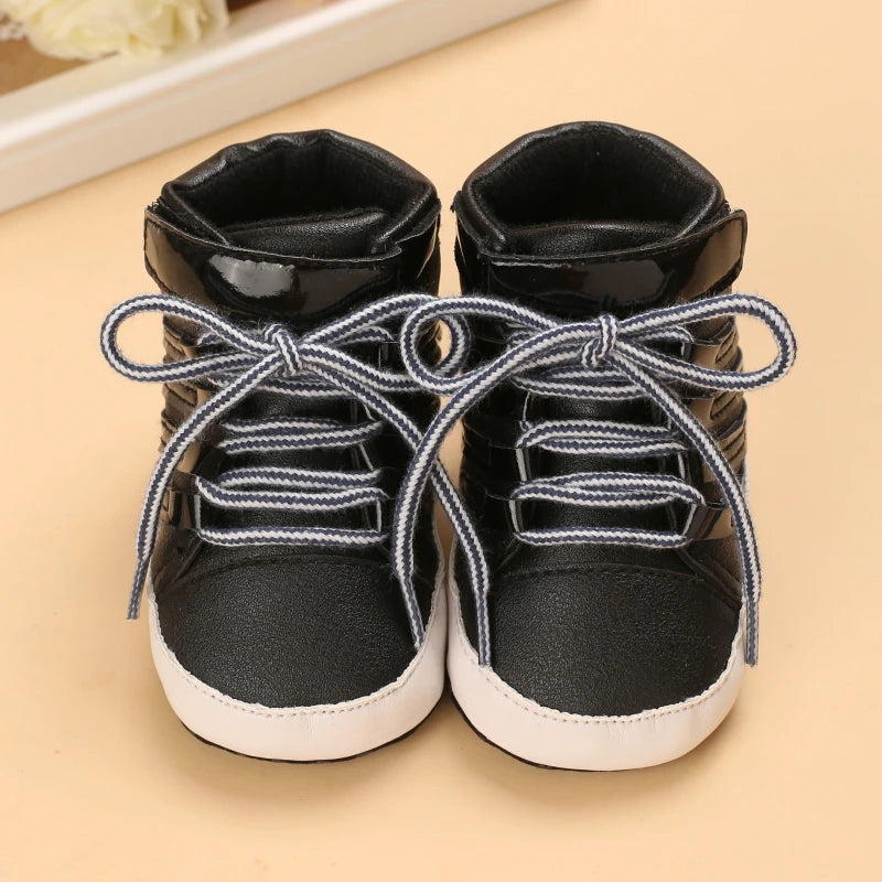 Pair of black high-top sneakers with white soles on a beige surface