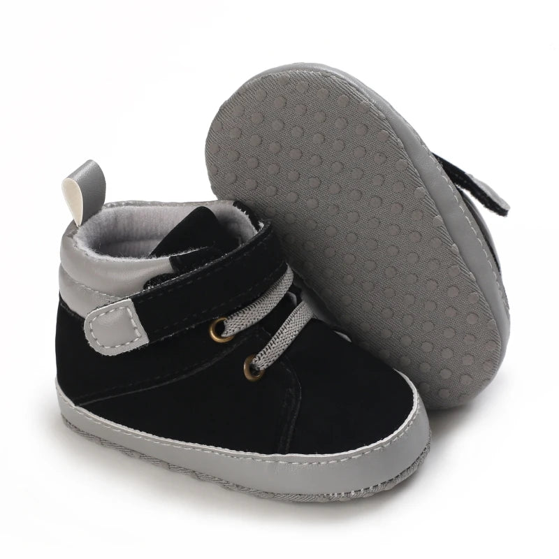 Black and gray baby shoes with velcro straps on a white background
