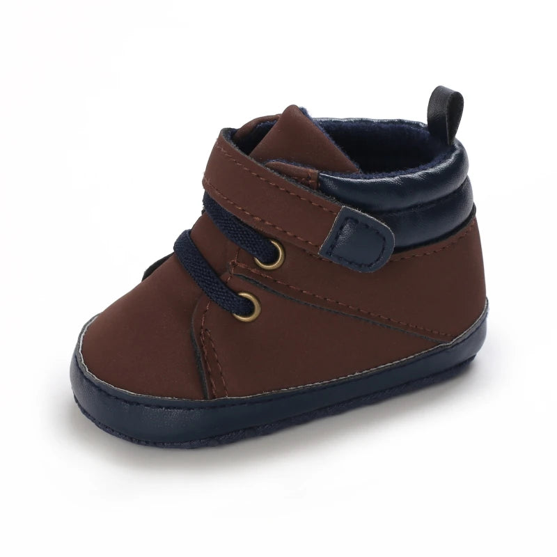 Brown and navy baby bootie shoe on a white background