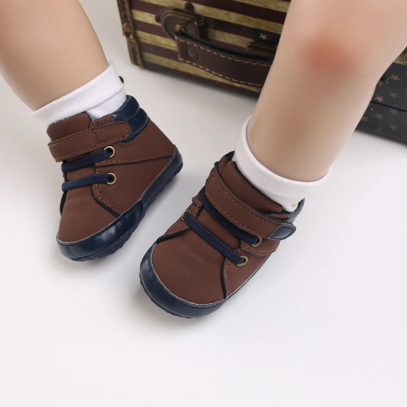Brown baby shoes with blue soles worn by a child on a white background