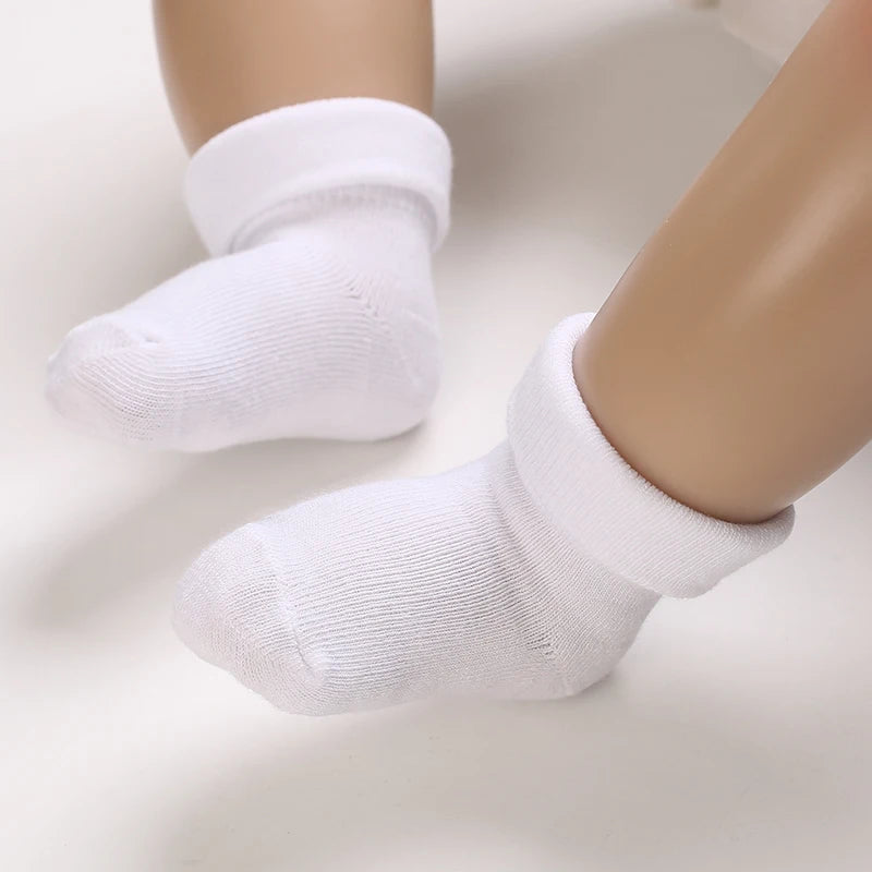 White socks worn by a baby on a light background