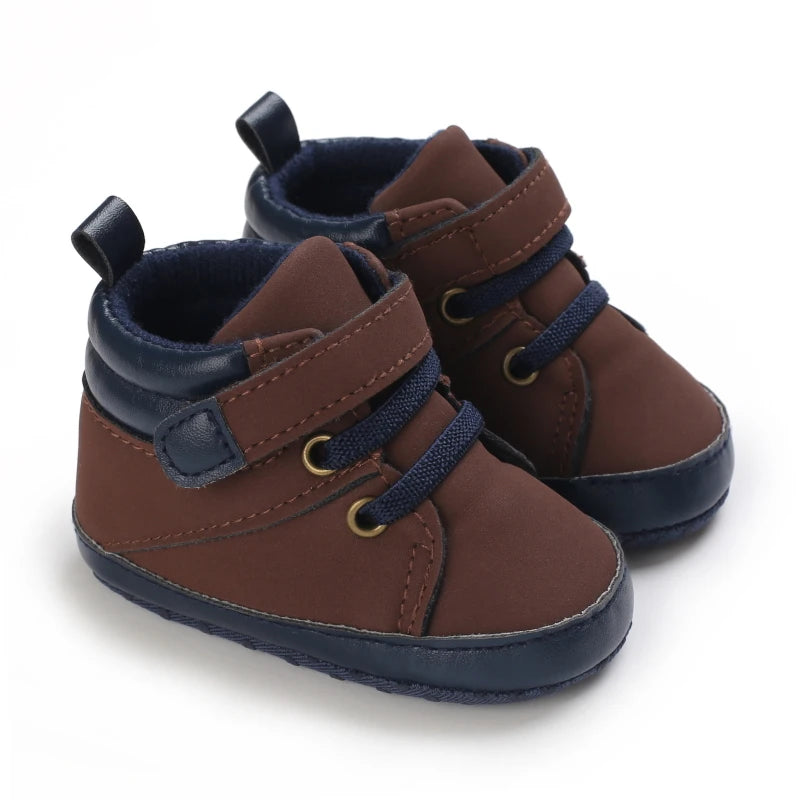 Pair of brown and navy baby shoes on a white background