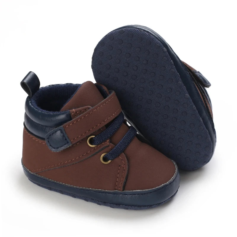 Pair of brown and navy baby shoes on a white background