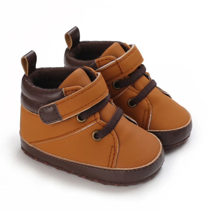 Pair of brown baby shoes with brown accents on a white background