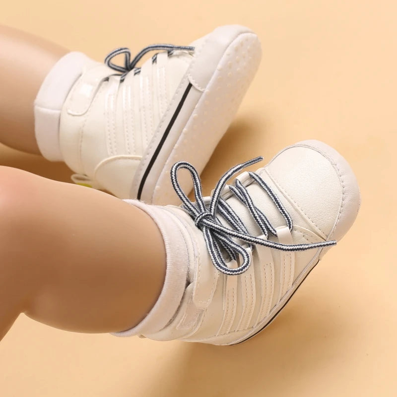 White sneakers with blue laces worn by a person on a beige background