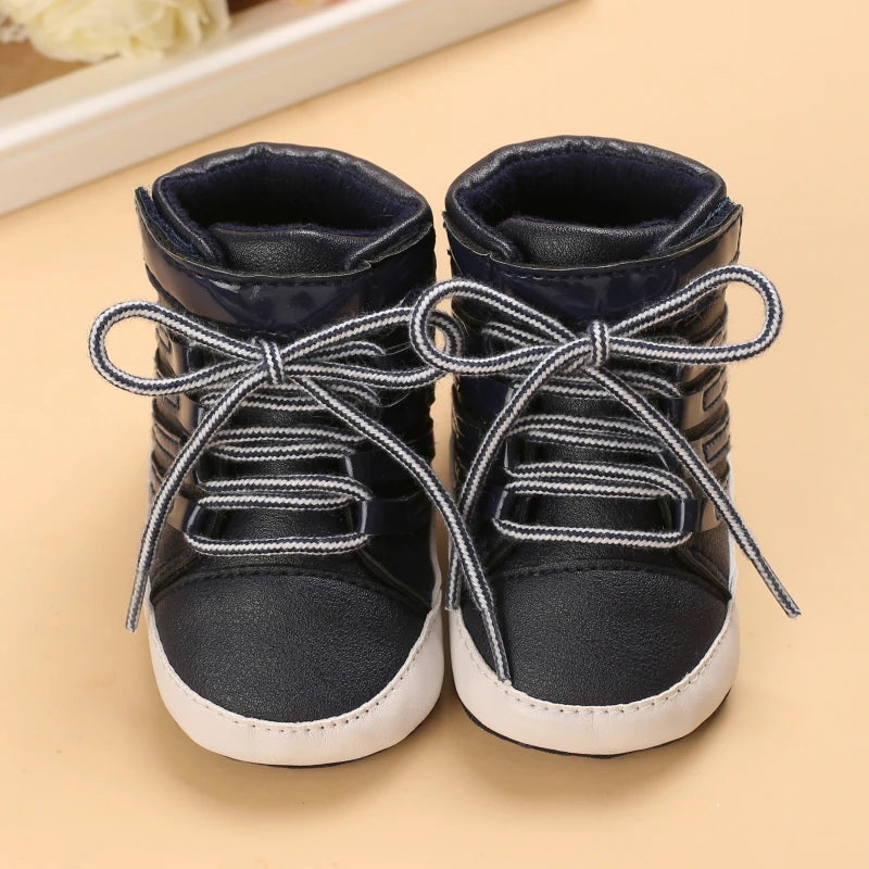 Pair of black high-top sneakers with white soles on a beige surface