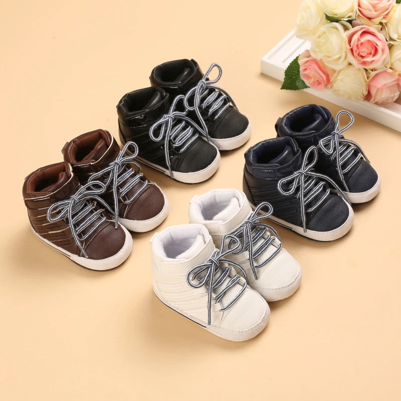 Set of baby shoes in brown, black, and white on a beige background with flowers.