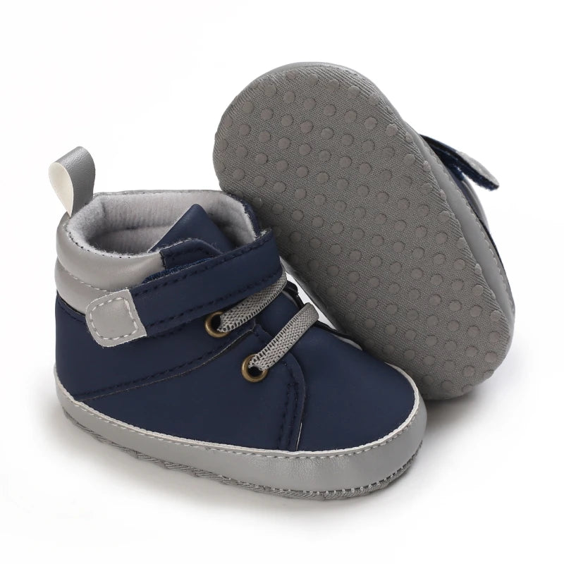 Navy and gray baby shoes with textured sole on a white background