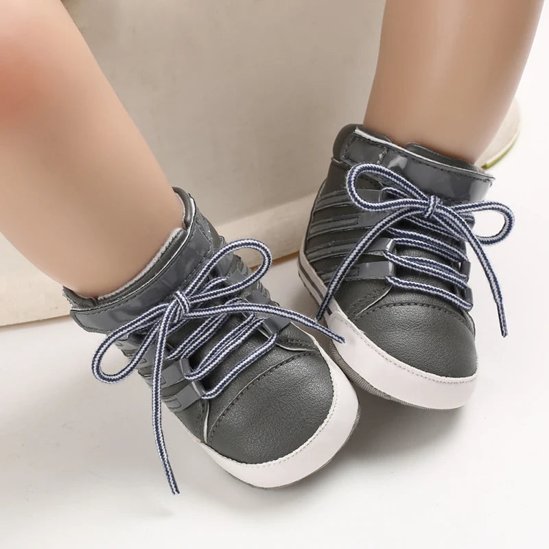 Gray high-top sneakers with blue laces worn by a child on a light background