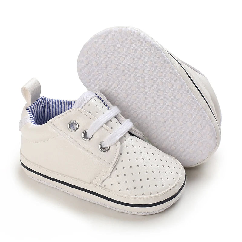 White baby sneakers with blue lining on a white background