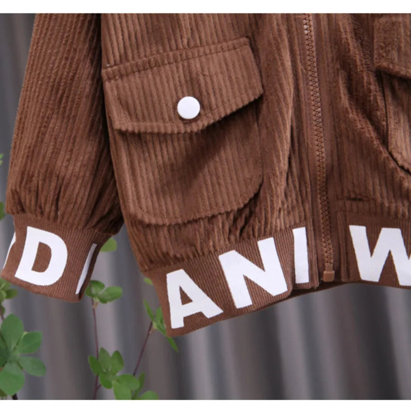 Brown corduroy jacket with white lettering on a blurred background