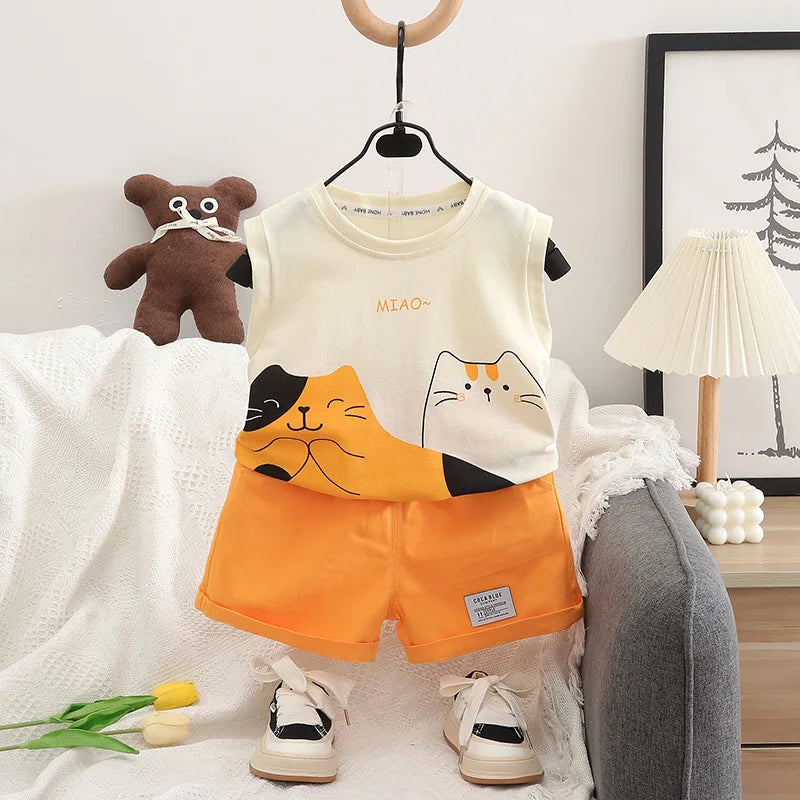 Children's outfit with cartoon cat design on a hanger, surrounded by a teddy bear and lamp.