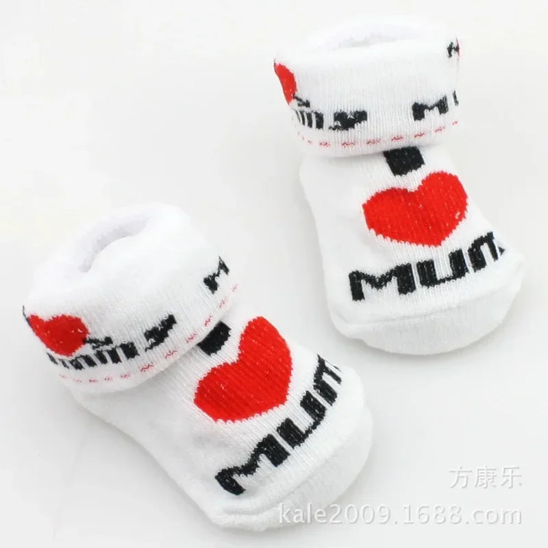 White baby socks with red hearts and black text on a white background