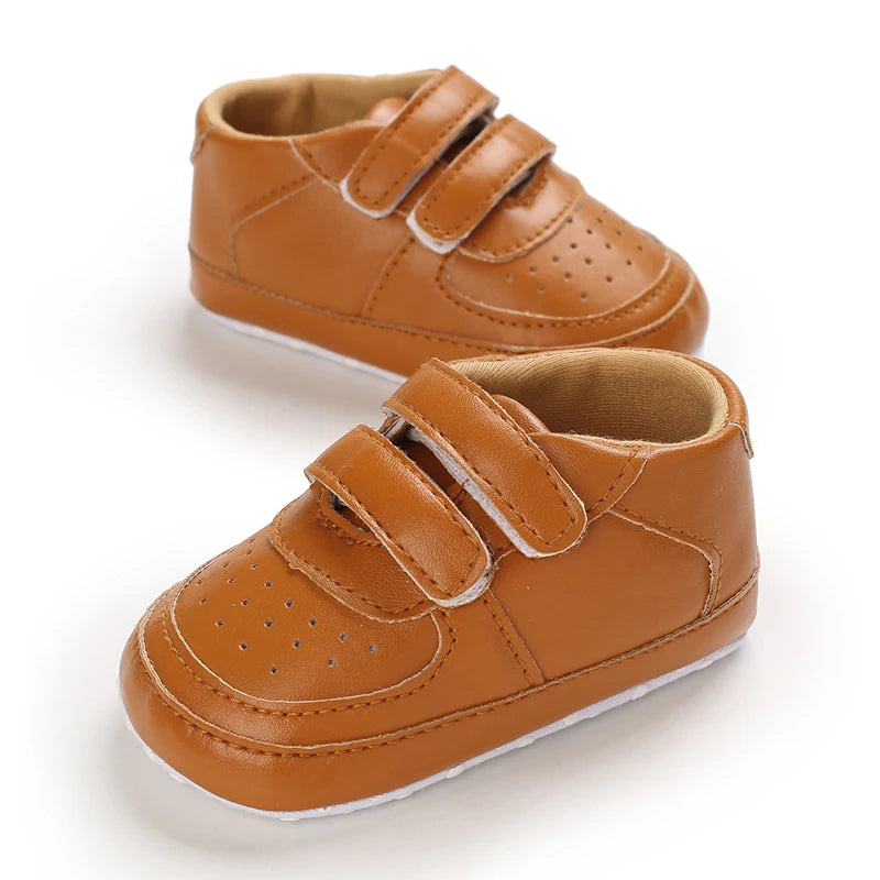 Pair of brown children's shoes with velcro straps on a white background