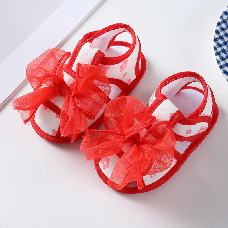 Red sandals with large bows on a white background