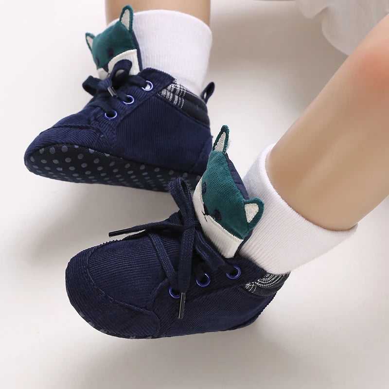 Navy blue baby shoes with green accents on white socks against a white background