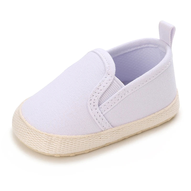 White baby shoe with a light brown sole on a white background