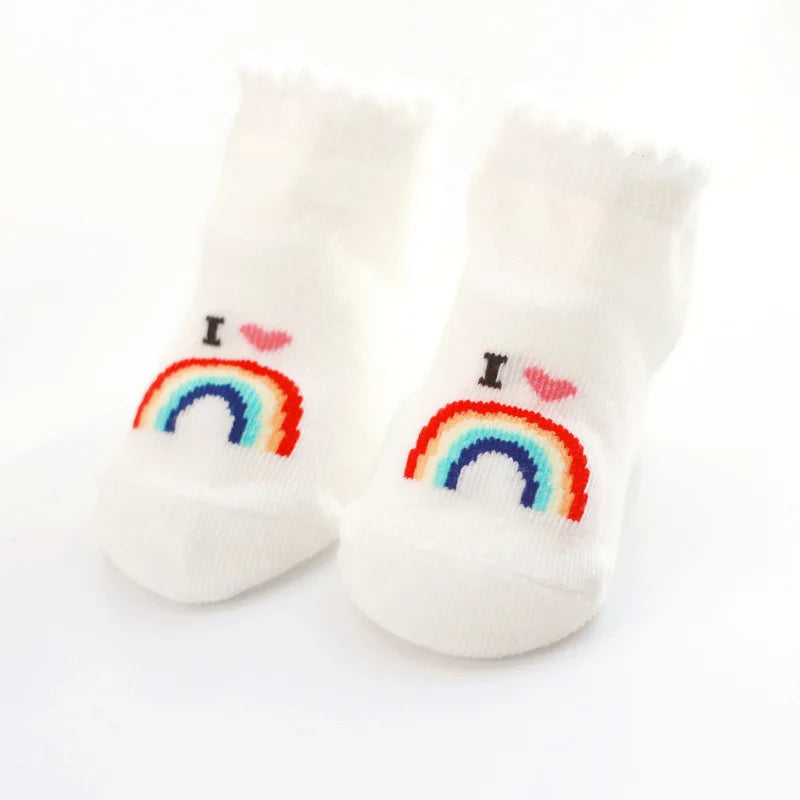 Pair of white socks with rainbow and heart designs on a white background