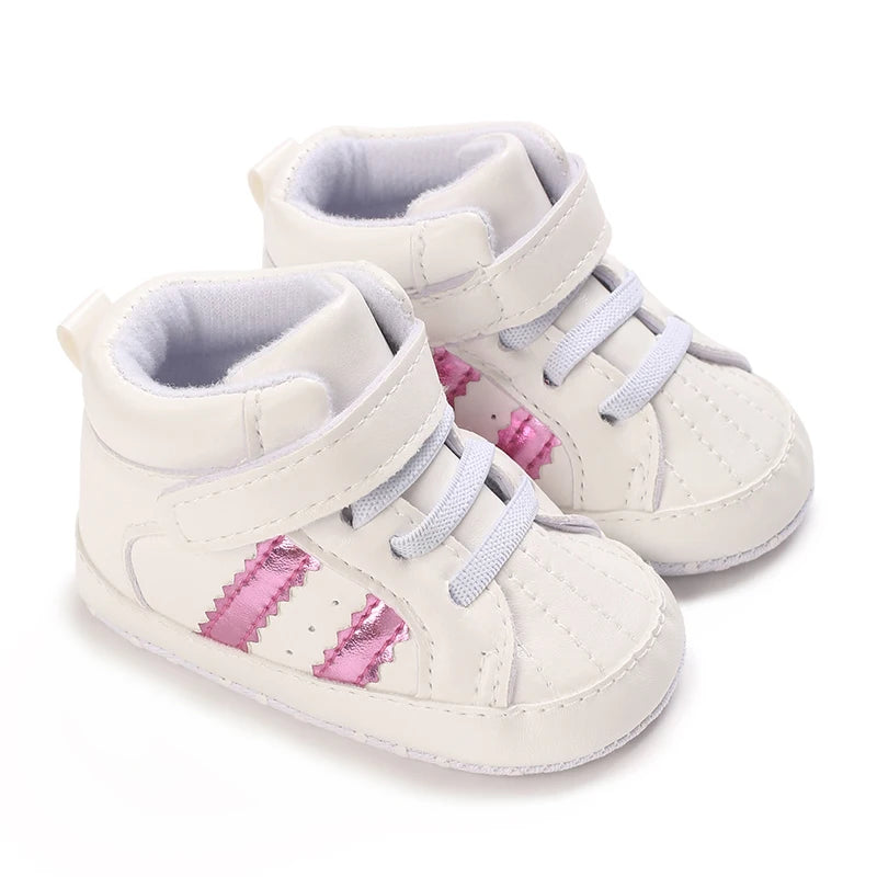 White baby shoes with pink accents on a white background