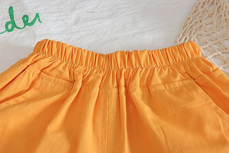 Close-up of orange shorts with a textured surface in the background