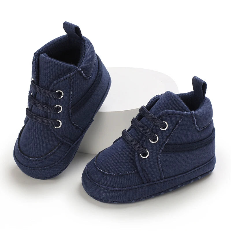 Pair of navy blue baby shoes on a white background