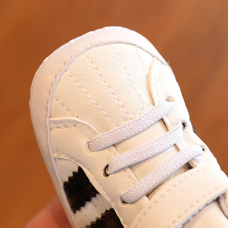 Close-up of a beige sneaker with white laces on a brown background