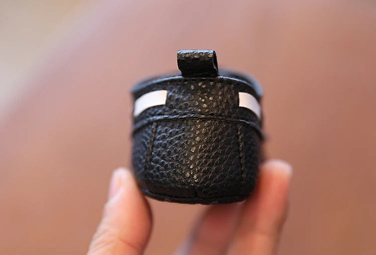 Black leather case held in a hand with a blurred background