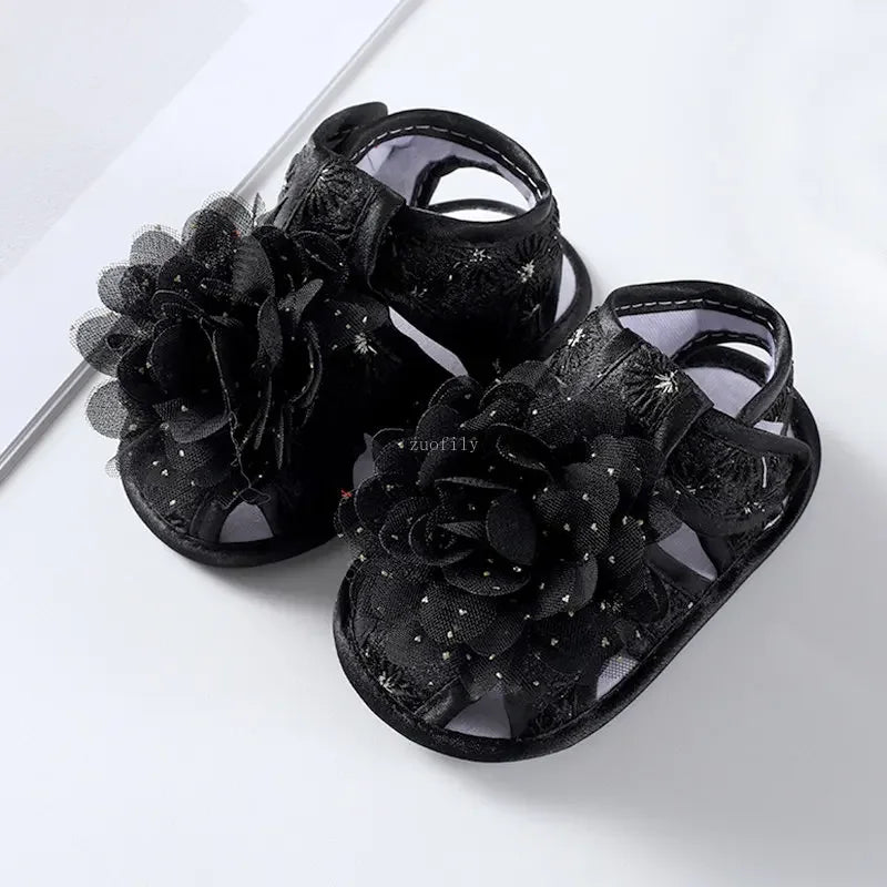 Black floral sandals on a white background
