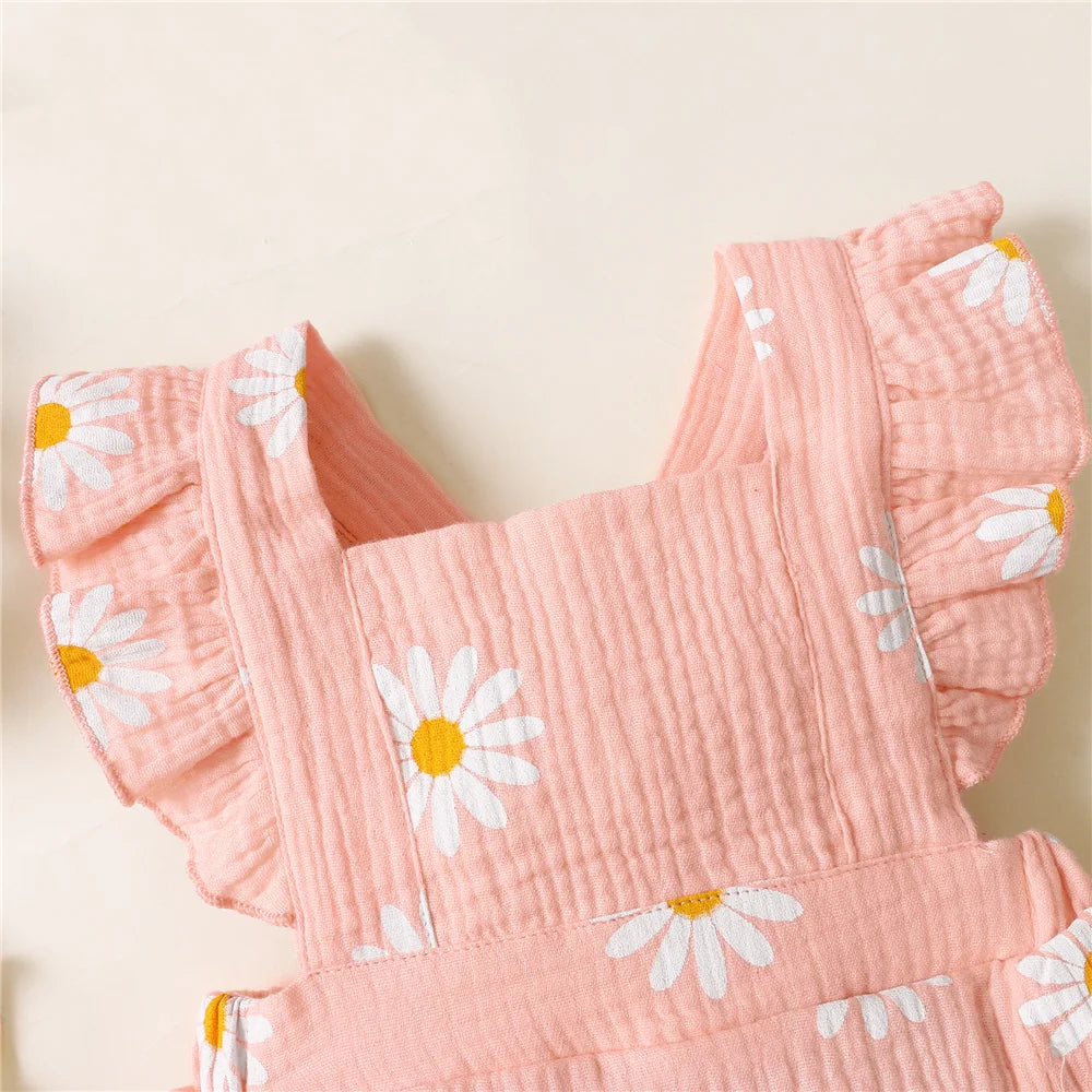 Pink baby romper with white daisy patterns on a light background