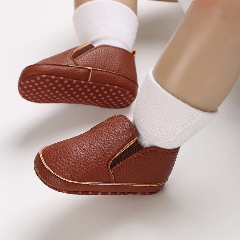 Brown baby shoes with white socks on a light background