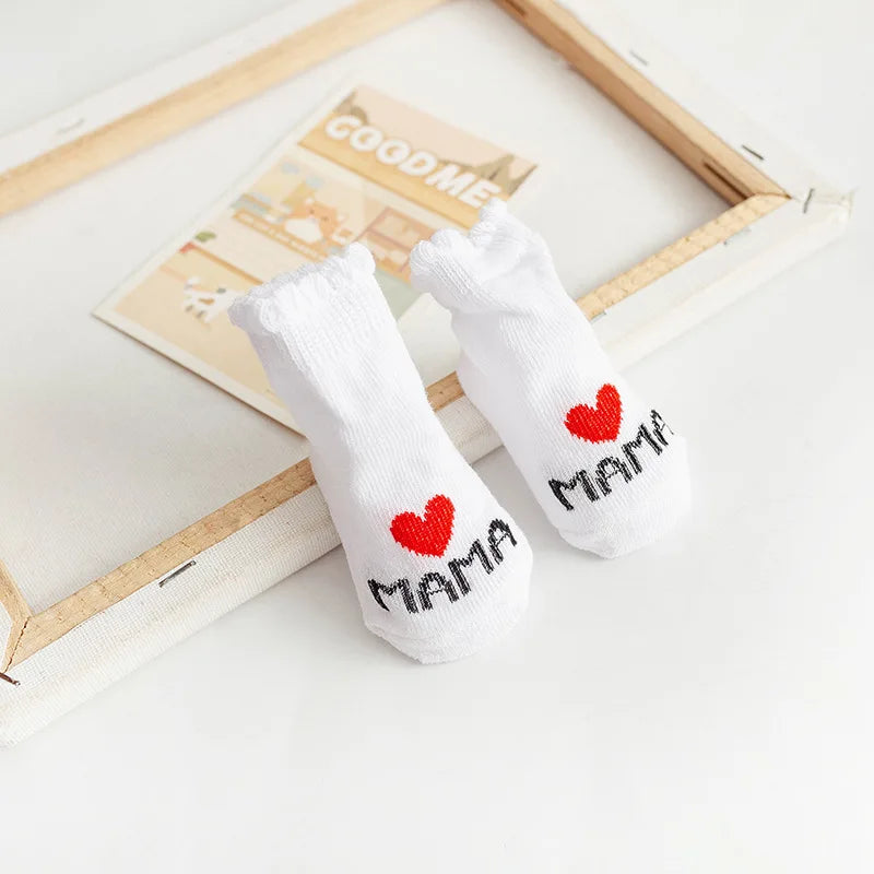 White socks with red hearts and 'MAMA' text on a light background