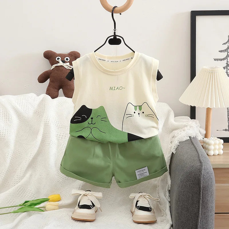 Children's outfit with a white tank top and green shorts on a hanger, surrounded by a teddy bear and decor items.