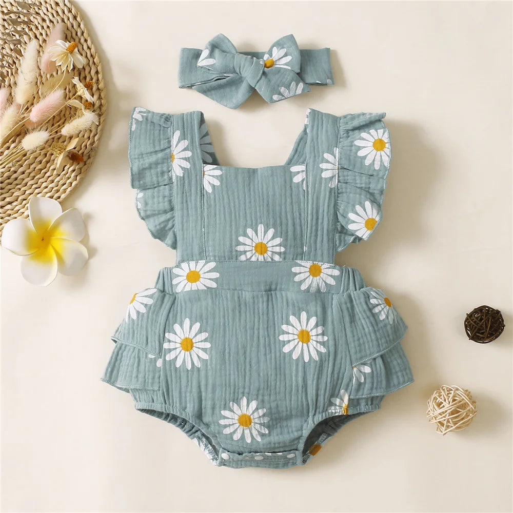 Baby romper with floral pattern and matching headband on a light background