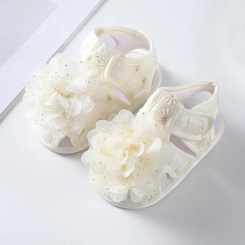 Pair of white sandals with floral designs on a light gray background