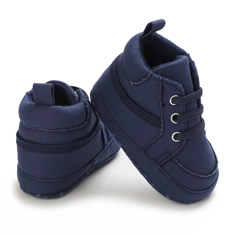 Pair of navy blue baby shoes on a white background