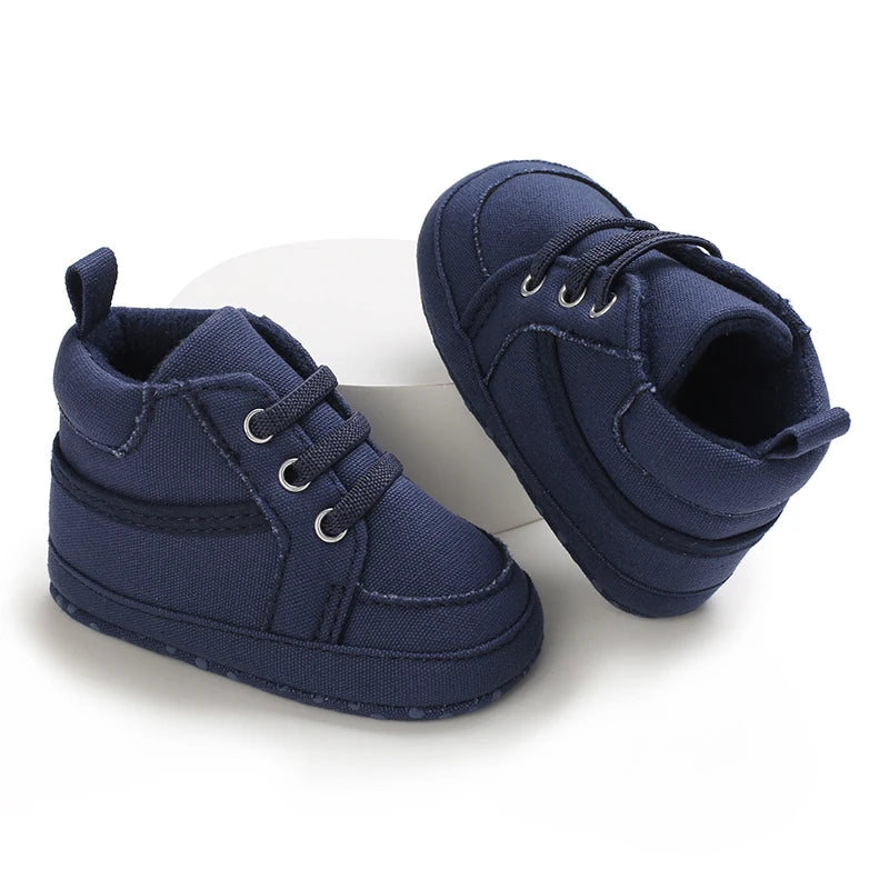 Pair of navy blue baby shoes on a white background