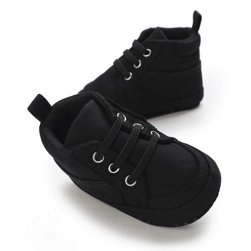 Black baby shoes with soft soles on a white background