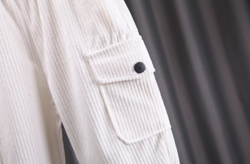 Close-up of a light-colored corduroy jacket with a button on a dark background