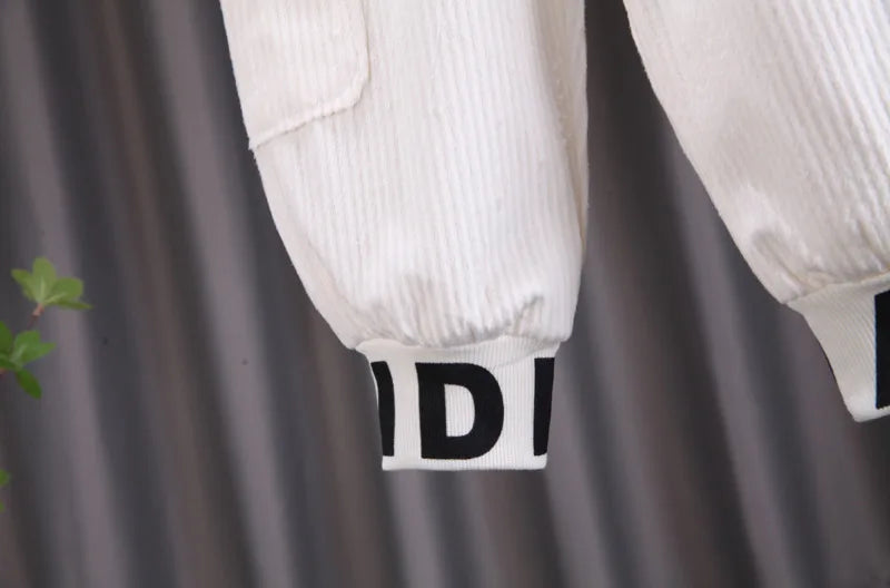 Close-up of white pants with black branding on a gray background