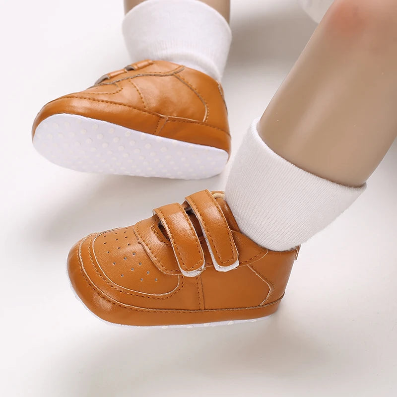 Brown baby shoes with white socks on a light background