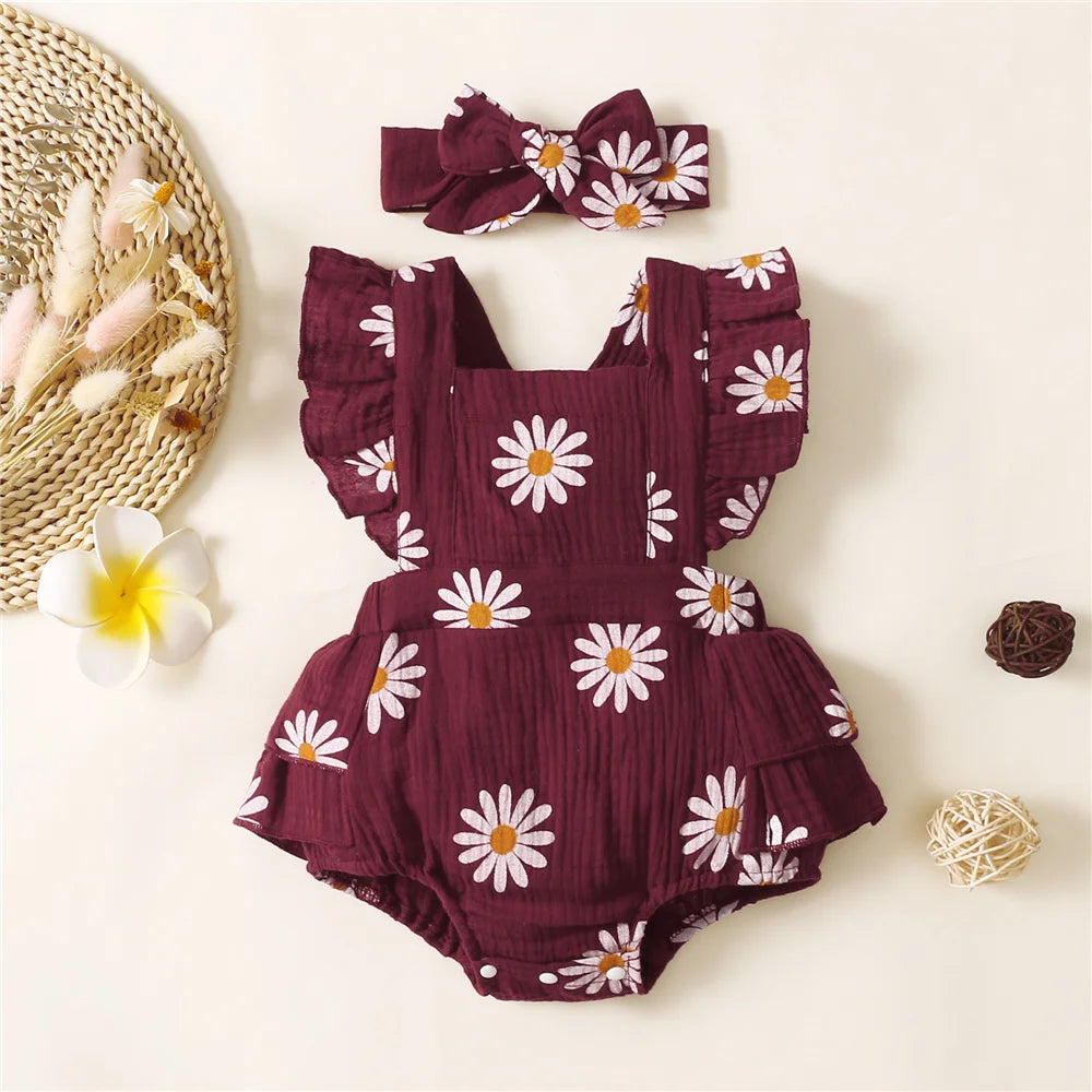 Baby romper with floral pattern and matching headband on a light background