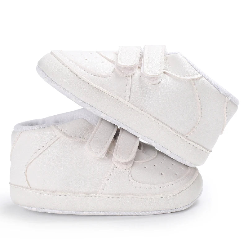 White baby shoes with bows on a white background