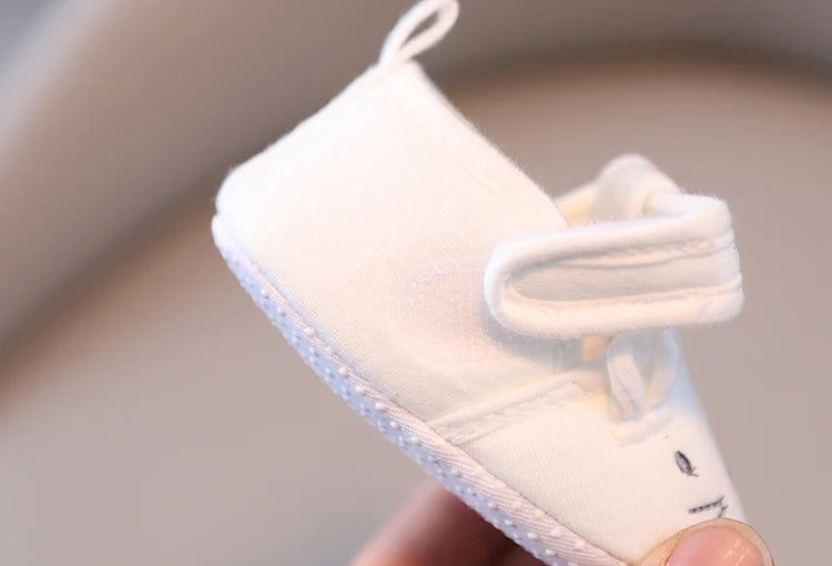 White baby shoe with a small design on a neutral background