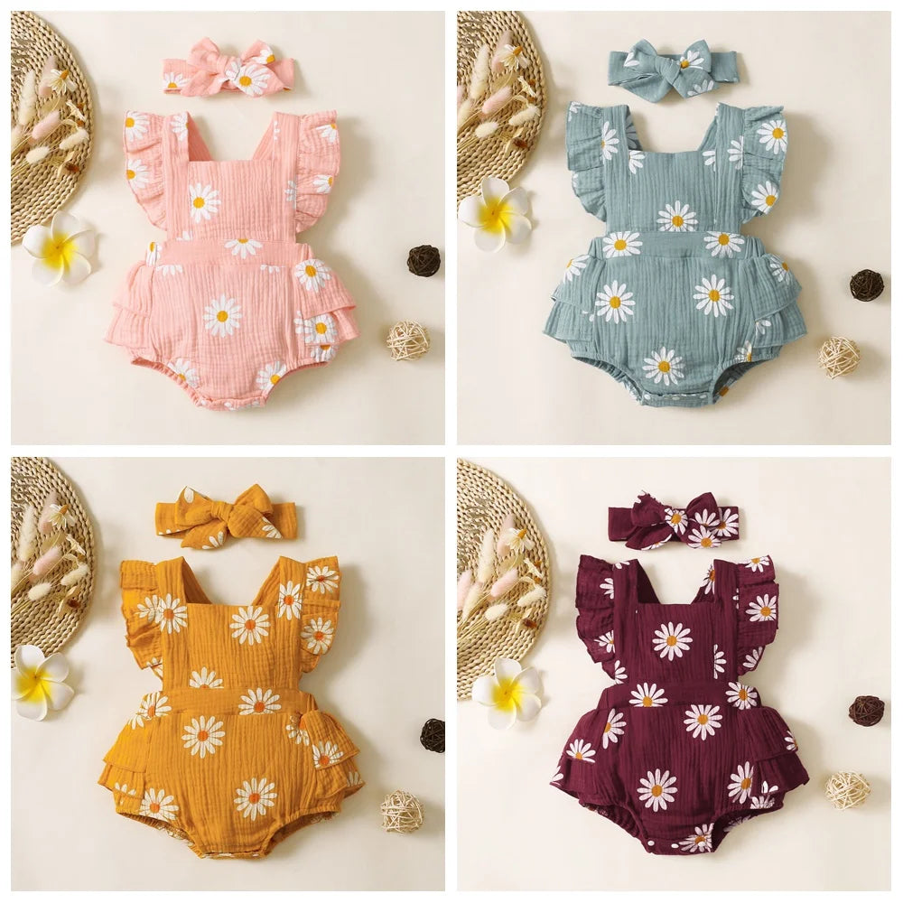 Four baby rompers in pink, blue, yellow, and purple with floral patterns on a beige background.