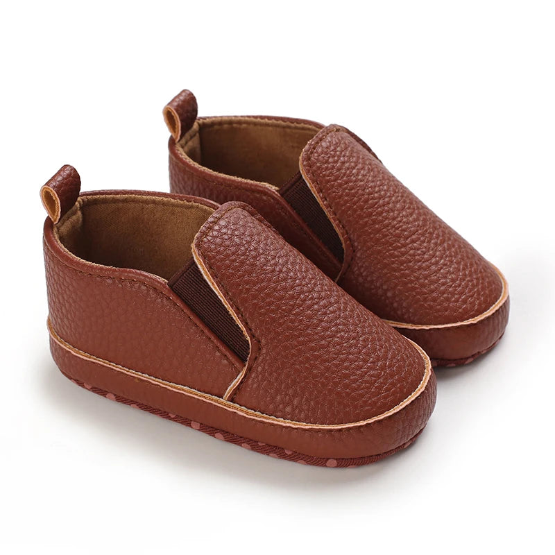 Pair of brown baby shoes on a white background