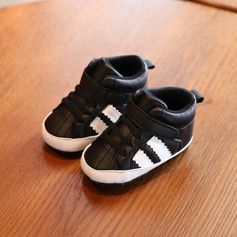 Black and white children's shoes on a wooden surface