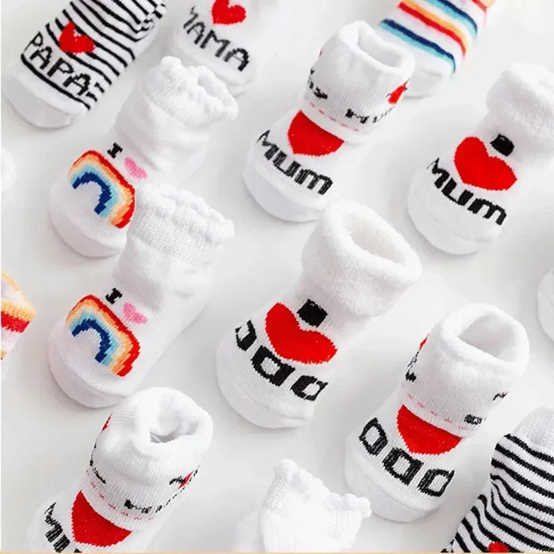 Set of baby socks with 'Mum', 'Dad', and rainbow designs on a white background