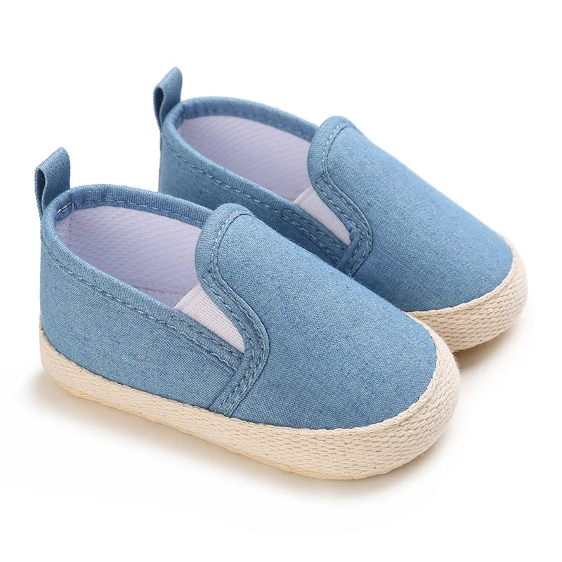 Pair of blue baby shoes with white soles on a white background